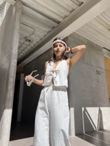 Top beige a rayas verticales, con escote halter y lazos ajustables en el frente y la espalda.