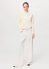 Sweater de punto fino color blanco marfil, de corte recto, con cuello perkins y manga larga.