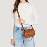 Cartera bandolera Guess modelo Carrie Mini, de color marrón con acabado en símil cuero. Cuenta con solapa frontal, herrajes dorados, detalle de la letra G en el cierre y correa ajustable combinada con cadena.