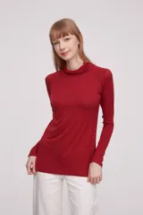 Polera de viscosa color rojo, de corte ajustado al cuerpo, con cuello alto y mangas largas.