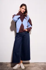 Sweater de tejido de punto con diseño de rombos (argyle) en tonos azul claro y marrón oscuro. Presenta cuello redondo y puños y cintura acanalados.