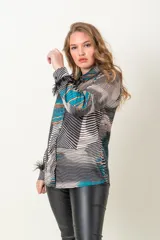 Camisa italiana de satén con estampado abstracto en tonos negro, beige y celeste. Tiene cuello clásico, cierre frontal con botones y mangas largas con puños adornados con plumas negras.