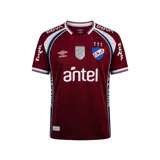 Camiseta de arquero Umbro del Club Nacional de Football, color bordó con detalles en blanco y azul. Presenta cuello en V, sponsors estampados y escudo del club en el pecho.