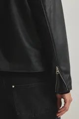 Campera negra de efecto cuero con cuello camisero, cierre frontal y bolsillos laterales con cierre. Presenta un corte estándar y forro interior.