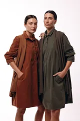 Vestido camisero de silueta amplia y fluida, color verde militar, con cuello camisero, frente abotonado parcial, mangas largas y bolsillos laterales.