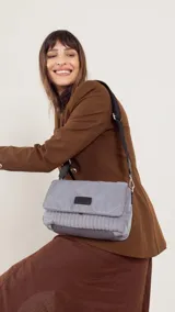 Bandolera capitoneada color bordó, con bolsillo interno, correa de galón ajustable y tapa con broche.