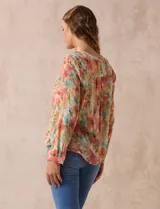 Blusa estampada de Zac & Rachel con cuello a la base, escote en V y botones. Tiene un bolsillo aplicado en la parte delantera, mangas largas regulables con presilla y botón, y terminación anudada opcional.