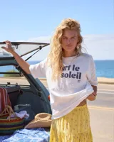 Remera Billabong color beige de corte oversize, manga corta y cuello redondo. Cuenta con estampa frontal con la inscripción "Surf le Soleil" en tonos oscuros y logo de la marca.