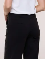 Pantalón crop blanco de corte recto con cintura ancha y botones decorativos laterales. Cuenta con bolsillos y pinzas frontales.