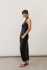 Pantalón holgado negro tipo bombacho, con cintura elástica y puños fruncidos en los tobillos.