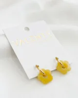 Aros dorados con dije de flor amarilla de acrílico. El diámetro del aro es de 1,5cm y el diámetro de la flor es de 1,5cm. El material del aro es acero.