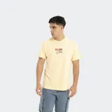 Remera amarilla de corte oversize con estampado frontal de la marca Reef y motivos playeros.