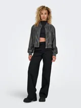 Chaqueta bomber corta de cuero sintético efecto gastado en color negro, con cuello redondo, cierre frontal de cremallera, bolsillos ribeteados y puños y cintura acanalados.