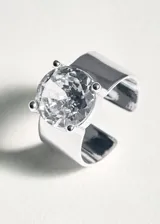 Anillo ajustable de diseño abierto, confeccionado en latón plateado con un cristal central engastado.
