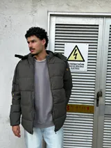 Campera puffer verde oscuro con capucha y cierre frontal.