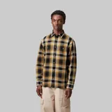 Camisa de franela de manga larga, con cuello clásico y botones frontales. Presenta un patrón de cuadros en tonos amarillo mostaza, negro y blanco.
