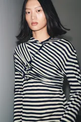 Jersey de punto con cuello redondo y manga larga, con estampado de rayas horizontales blancas y azul marino.