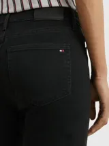 Pantalón de jean negro, corte skinny, con cierre de botón y cremallera, cinco bolsillos y parche de Tommy Hilfiger en la parte posterior de la cintura.