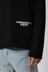 Sweater de punto liviano color negro con textura marcada, diseño de cuello redondo y calce holgado.