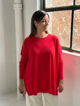Sweater de punto color rojo, con cuello redondo, mangas largas con puños acanalados y diseño holgado con detalle de costura vertical central.