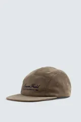 Gorra de cinco paneles confeccionada en pana de algodón, con visor plano y ajuste posterior. Presenta un bordado frontal con el texto 'Lassen Field'.