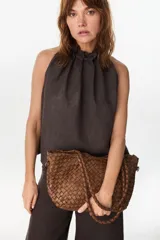 Cartera de cuero marrón con diseño trenzado y asas de mano rígidas, de estilo atemporal y versátil.
