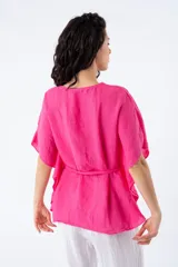 Blusa fucsia de viscosa, corte suelto, escote en V y mangas cortas tipo kimono. Incluye lazo del mismo material para ajustar a la cintura.