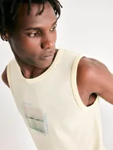 Musculosa de hombre color beige, de corte clásico y sin mangas, con pequeño estampado tipográfico en el pecho.