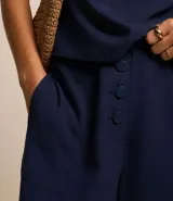 Pantalón pantacourt de viscosa color blanco, con bolsillos laterales y cierre con botones delanteros.