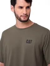 Remera de manga corta y cuello redondo, color verde oliva. Presenta el logo de la marca estampado en pequeño en el lado izquierdo del pecho y una etiqueta envolvente en el dobladillo.