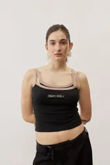 Musculosa de tejido rib color beige con detalles en marrón oscuro en el escote y doble tirante fino. Presenta un pequeño texto estampado en el pecho.