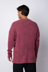 Buzo de corte oversize confeccionado en tela waffle de algodón con proceso de teñido acid wash. Presenta cuello redondo con detalle de costura en X y mangas largas con puños acanalados.