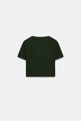 Camiseta cropped color amarillo, de corte slim fit, cuello redondo y manga corta.