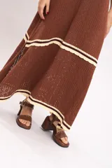 Vestido largo de tejido de punto color marrón, con tirantes anchos, escote cuadrado con detalles en tono bordó y franjas horizontales en color crema con terminación ondulada.