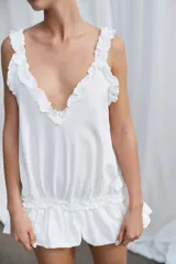 Top de tirantes con escote en pico, detalle de volantes en los hombros y bajo con volado fruncido que aporta volumen.