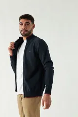 Campera tejida color verde militar, con cuello alto, puños y logo bordado.