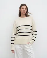 Sweater de tejido Bremer con diseño a rayas horizontales negras sobre base color crema, de corte holgado, cuello redondo y mangas largas con puños acanalados.