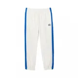 Pantalón de jogging blanco de corte recto con cintura elástica y cordón ajustable. Presenta una franja azul a lo largo de la pierna y el logo de Lacoste bordado en el muslo.