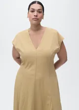 Vestido midi de manga corta en color beige, con cuello en V, diseño evasé, costuras decorativas visibles y cierre de cremallera en la parte posterior.