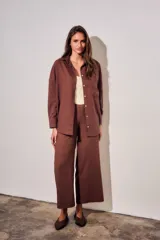 Camisa oversize color marrón, confeccionada en mezcla de viscosa y lino, con cuello clásico, cierre frontal con botones y un bolsillo aplicado en el pecho.