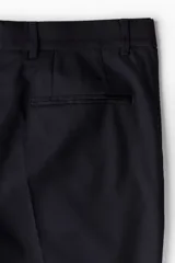 Pantalón de traje negro de corte slim fit, con bolsillos laterales, bolsillos traseros ribeteados y raya marcada en las perneras. Cuenta con cierre de cremallera y corchete oculto.
