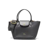 Cartera de mano y hombro color negro, estilo tote bag pequeño, con doble asa corta y correa larga desmontable y regulable. Presenta un bolsillo frontal con solapa y broche dorado, y herrajes metálicos dorados.