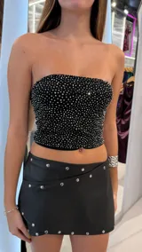Top strapless negro ajustado al cuerpo, cubierto de strass y brillos plateados en toda la superficie.