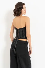 Top corset negro con escote corazón, diseño ajustado y detalles de lentejuelas horizontales.