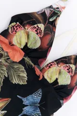 Malla enteriza con estampado animal print tipo cebra en tonos bordó y negro, con breteles cruzados en la espalda y bordes en color celeste.