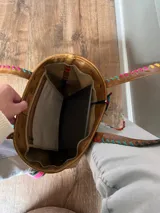 Bolso tote de cuero color marrón con costuras decorativas de hilo de colores.