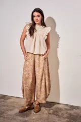 Babucha fluida de tiro alto con cintura elástica, diseño de rayas combinadas con estampado tipo toile de jouy en tonos beige y rojo.