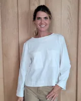 Remera de manga larga color marrón chocolate, con cuello redondo y dos bolsillos frontales tipo parche.