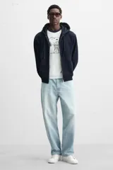 Zapatilla de cordones de caña baja, color negro, con capellada lisa y suela de goma blanca.