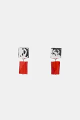 Aros colgantes con pieza superior cuadrada de metal plateado labrado y pieza inferior rectangular de resina roja.